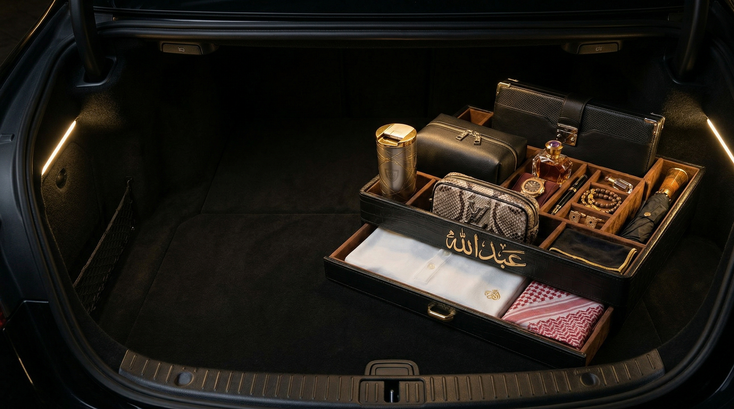 Trunk of a car with luxurious items including a suitcase, wallet, and cards.